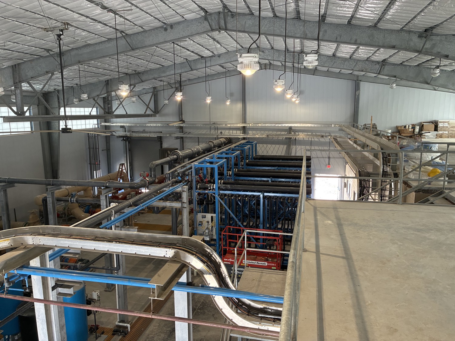 Wide angle view inside Ferguson Service Systems industrial facility showing extensive piping, process equipment, and modern infrastructure