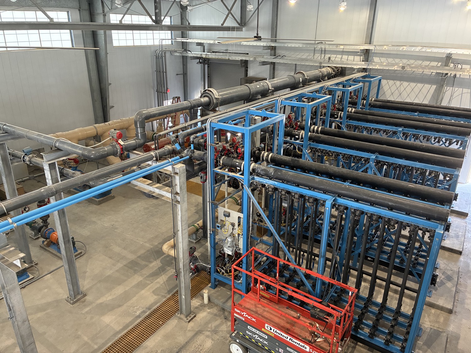 Blue structural pipe racks with extensive piping and valves in an industrial facility